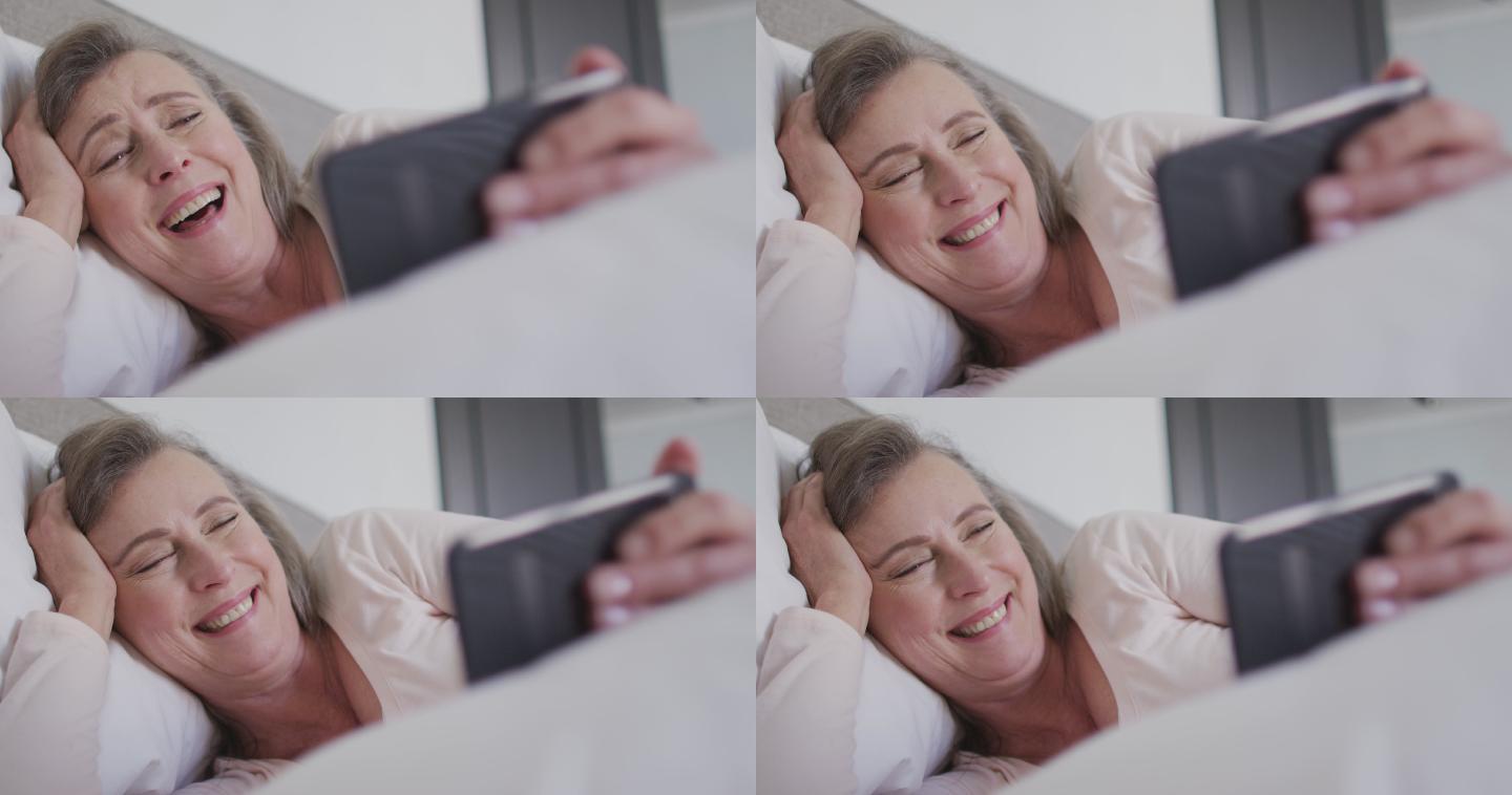 一名女子在床上用智能手机视频聊天