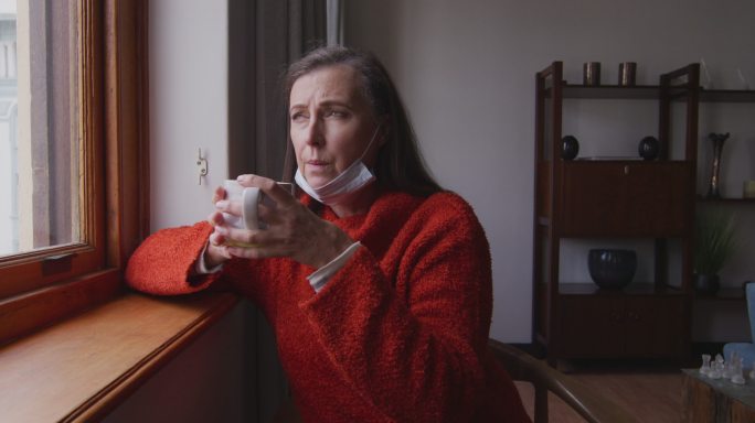 Woman drinking coffee while looking out of the win