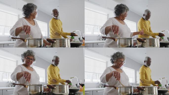 一对非洲裔美国老年夫妇在家做饭。隔离期间的社交距离