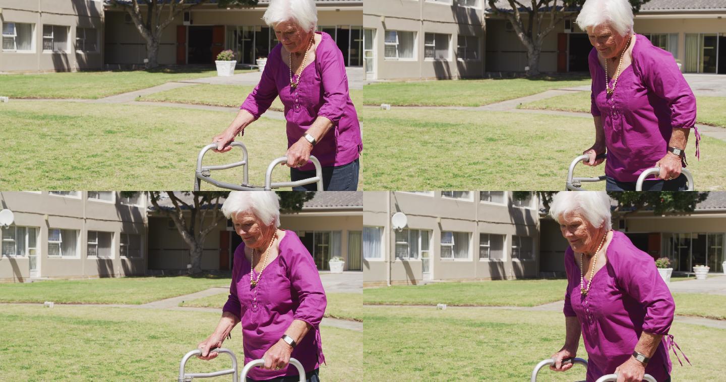 一位老妇人在养老院的公园里散步