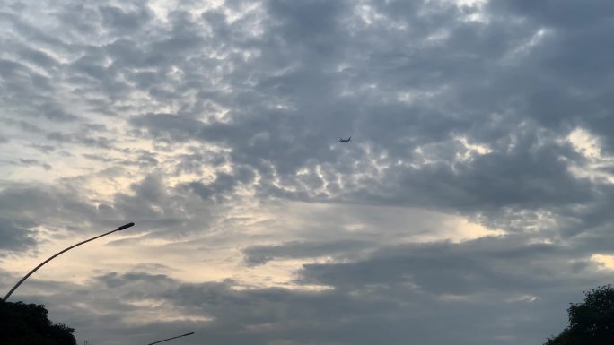 飞机在厚云前的剪影飞机掠过天空