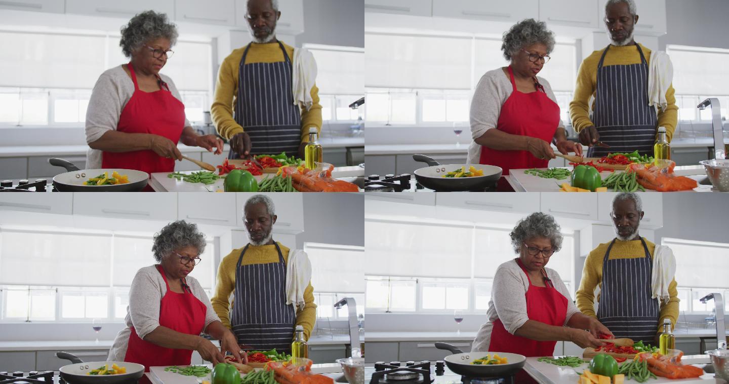 一对非洲裔美国老年夫妇在家做饭。隔离期间的社交距离