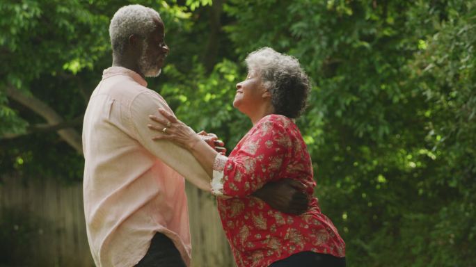 一对高级非裔美国人在花园跳舞以保持社交距离