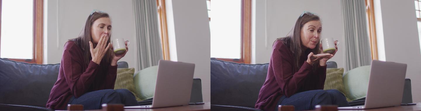 一个拿着咖啡杯在家用笔记本电脑视频聊天的女人