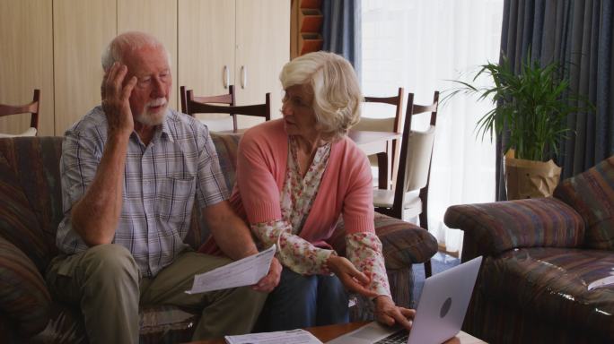 老夫妇用笔记本电脑保持社交距离