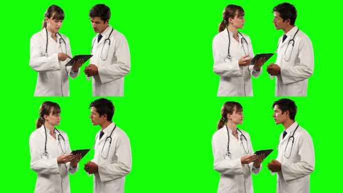 侧面的医生讨论和拿着一个绿色屏幕的数字平板电脑