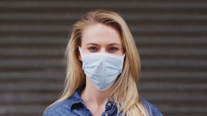 白人妇女戴着冠状病毒2019冠状病毒口罩的正面视图