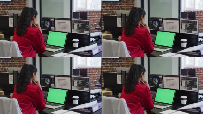 坐在办公桌上使用笔记本电脑的女人