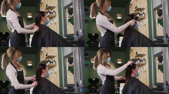 女发型师戴着面罩在发廊为女顾客梳头