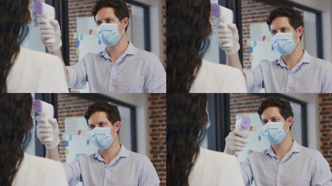 一名戴面罩的男子在办公室为一名女子检查体温