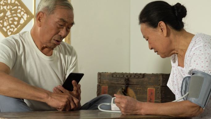 老年农民夫妇使用手机在线咨询医生