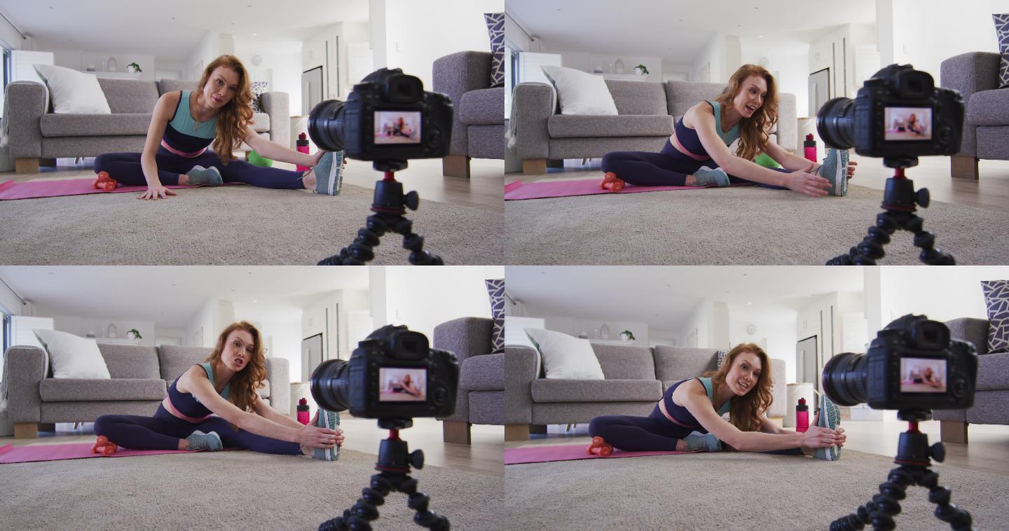 妇女在家里做运动并用数码相机记录下来