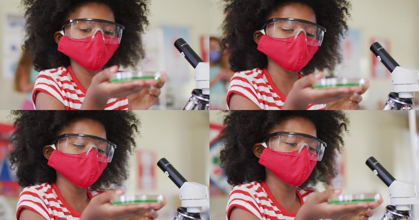 戴面罩和防护眼镜的女孩在实验室拿着装有化学品的容器