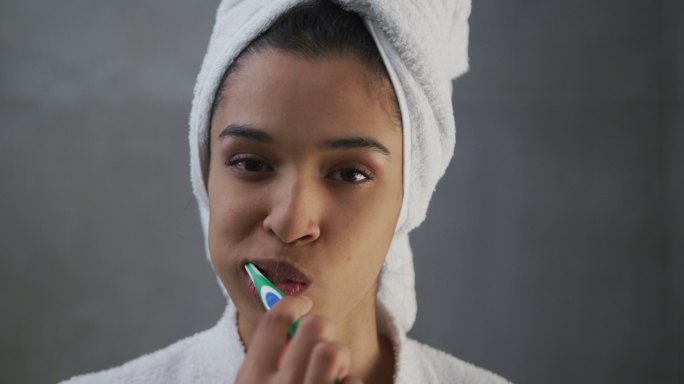 混血妇女在浴室刷牙的肖像