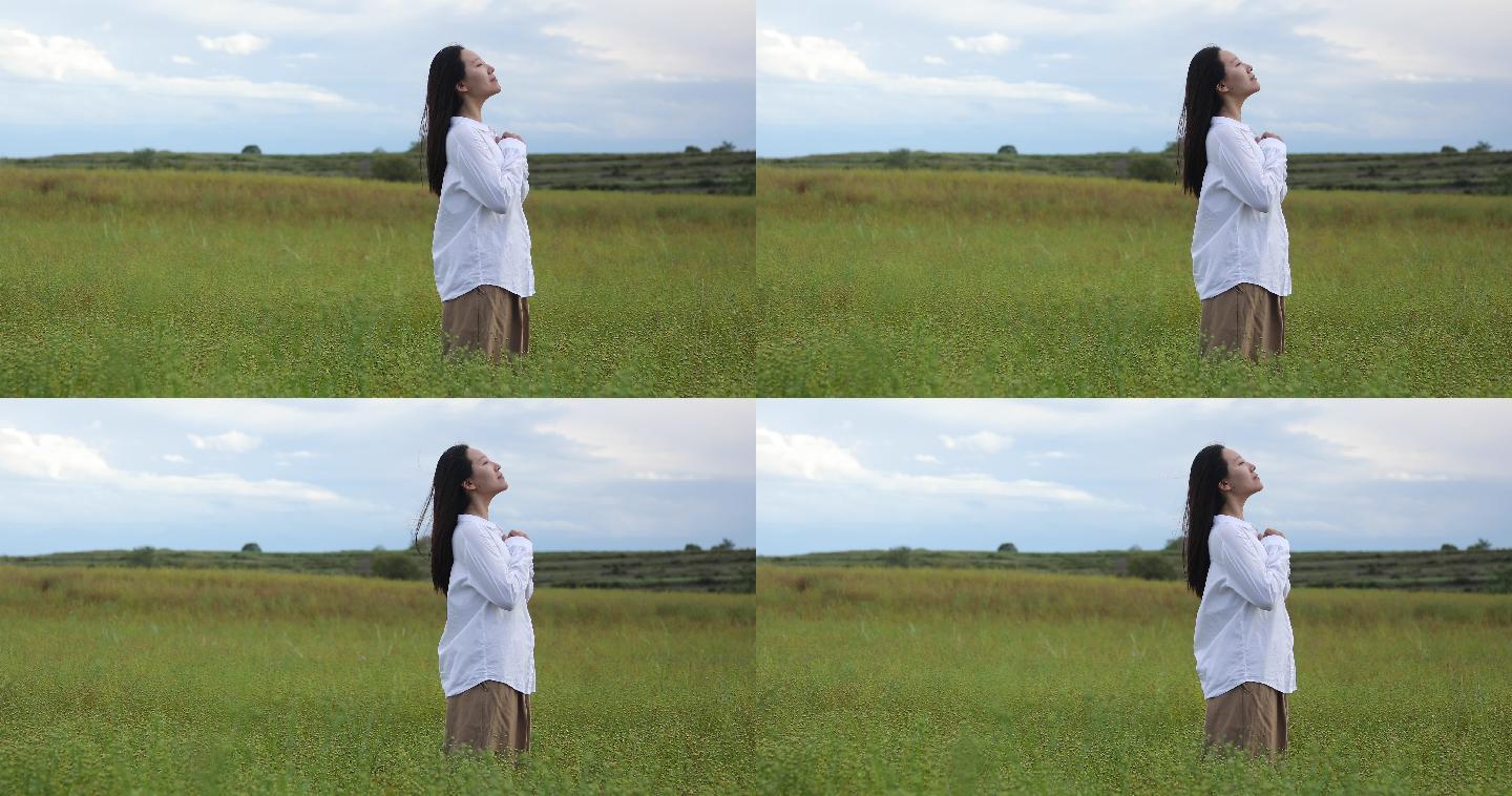 女子站在草原上实拍