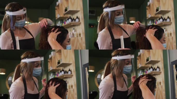 女发型师戴面罩为发廊的女顾客梳头
