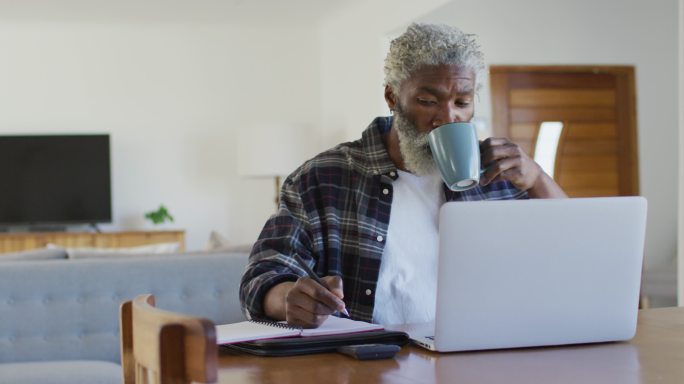 老人一边喝咖啡一边做笔记