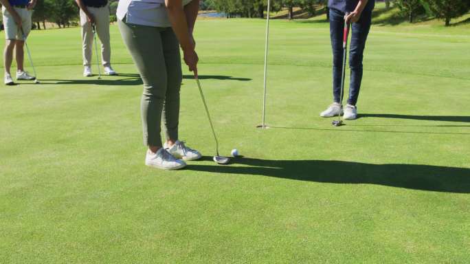 在一个阳光明媚的日子里，两个白人高级妇女在高尔夫球场练习高尔夫