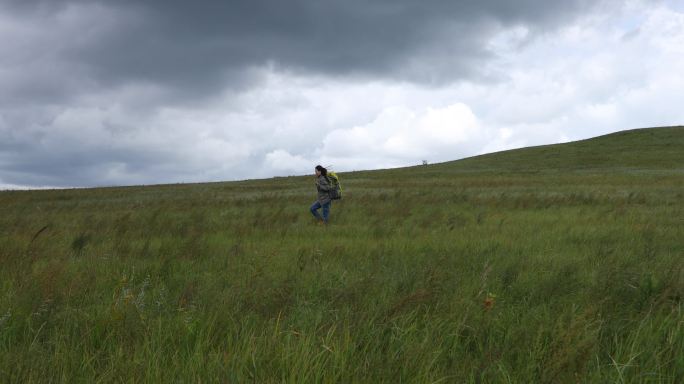 女背包客徒步在草原上实拍