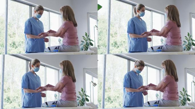 女卫生工作者在家伸展老年妇女的手腕