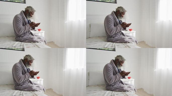 老人坐在家里的床上使用智能手机