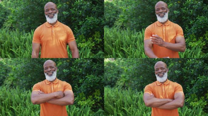 肖像的非洲裔美国高级男子微笑和交叉他的双臂在花园里