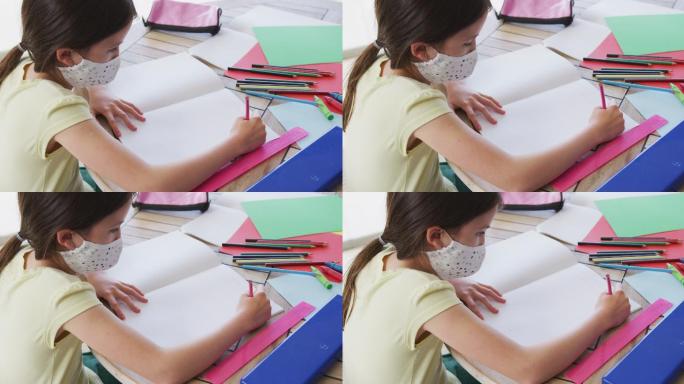 女孩戴着口罩在家做作业