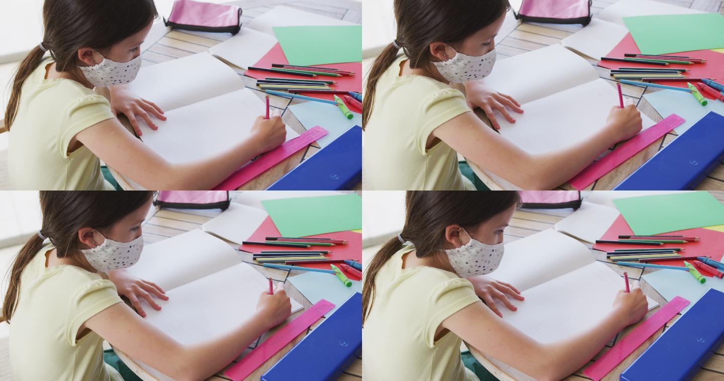 女孩戴着口罩在家做作业