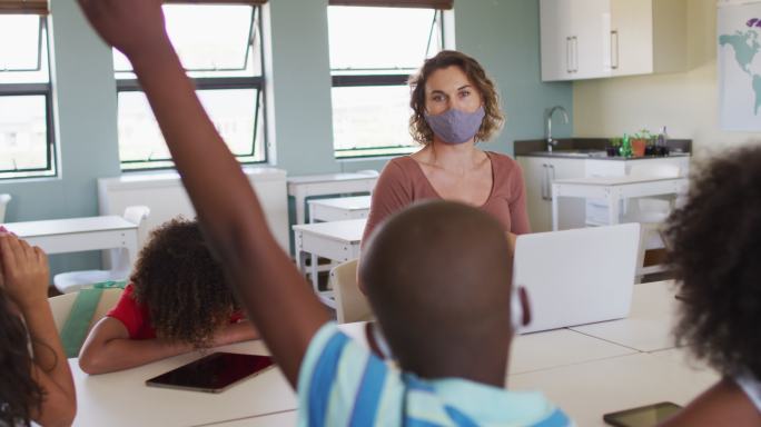 女老师戴着口罩在学校教小朋友上课