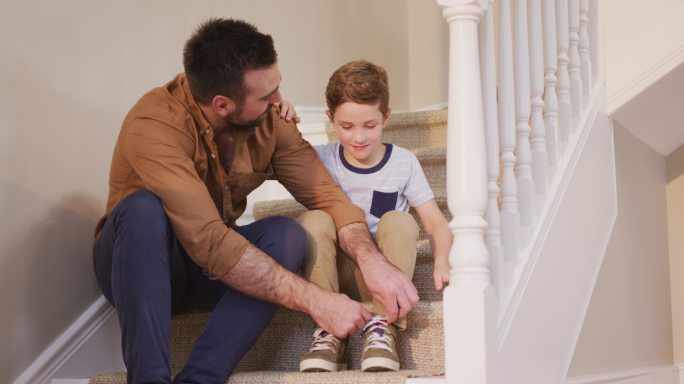 一个白人男人和他的儿子坐在楼梯上