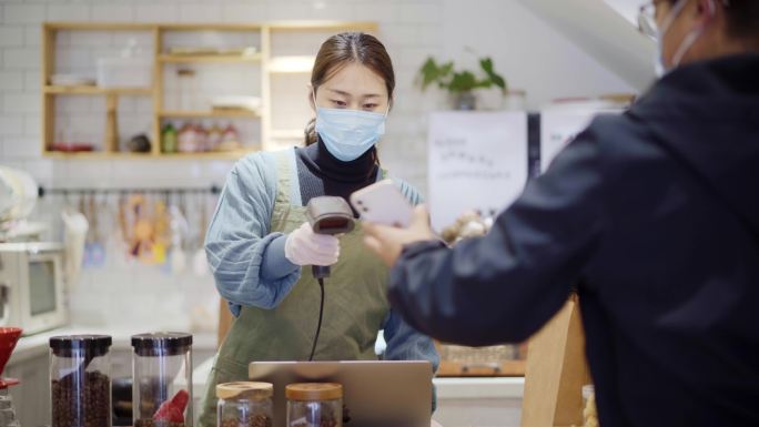 年轻女烘培店长扫码客户手机收款