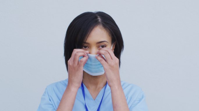 在白色背景下佩戴面罩的女性卫生工作者肖像