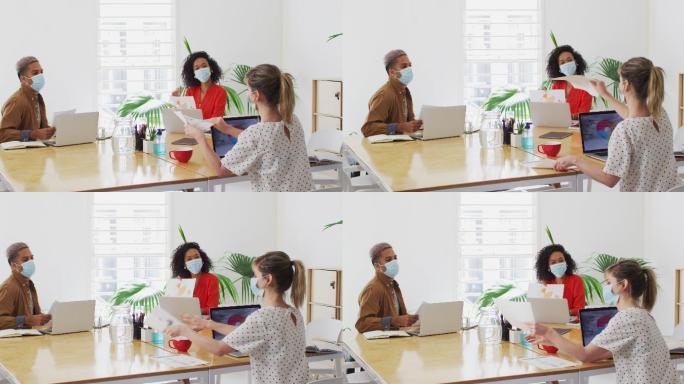 一名戴口罩的妇女在办公室向同事展示一份文件