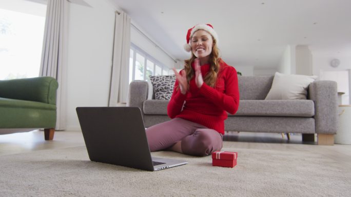 戴圣诞帽的女人正在家里用笔记本电脑视频聊天