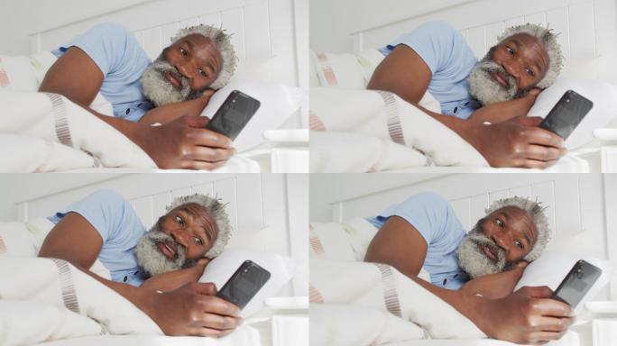 老人躺在家里的床上使用智能手机