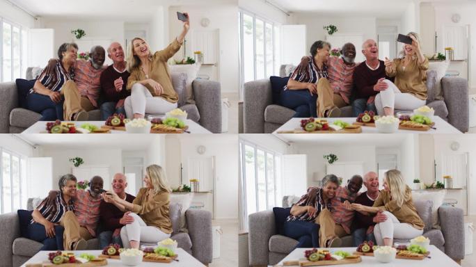两对不同的老年夫妇坐在沙发上，一边玩着智能手机一边大笑