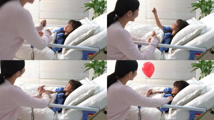 年轻妈妈给生病的小女孩拿气球