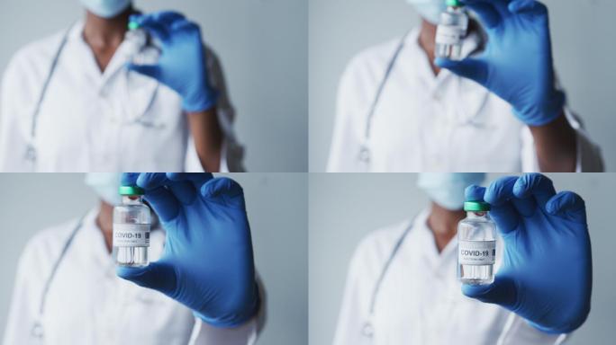 戴防护手套、手持covid-19疫苗的白人男性医生