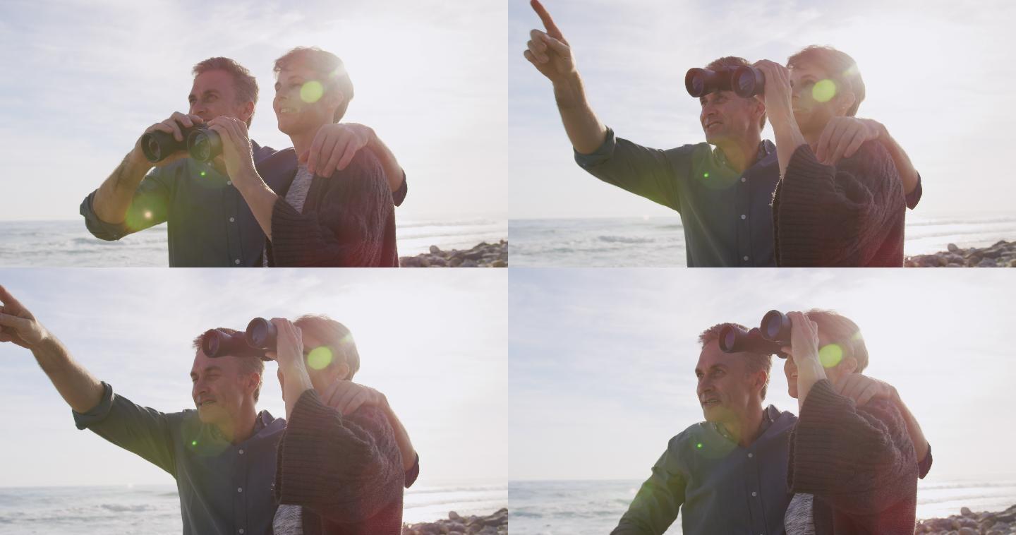 在阳光明媚的日子里，一对白种夫妇手持双筒望远镜，在海上享受自由时间