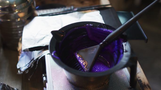 发廊的桌子上放着装满紫色染发剂的黑色碗