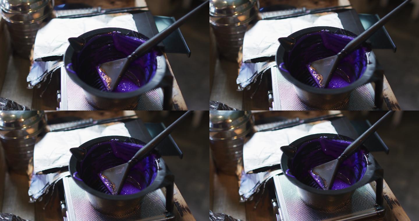 发廊的桌子上放着装满紫色染发剂的黑色碗