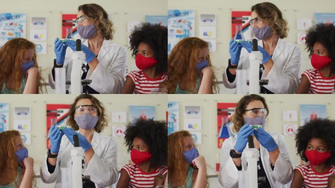 女教师戴着口罩和防护眼镜在实验室给学生上课