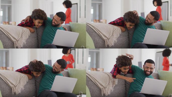 Father embracing his son while using laptop at hom