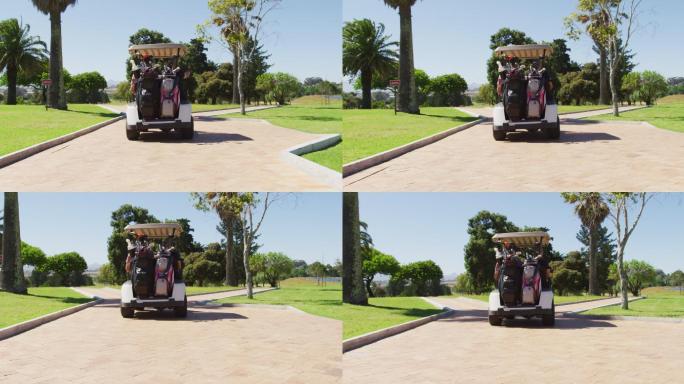 后视图的白人老年夫妇驾驶高尔夫球车与俱乐部在后面的高尔夫球场