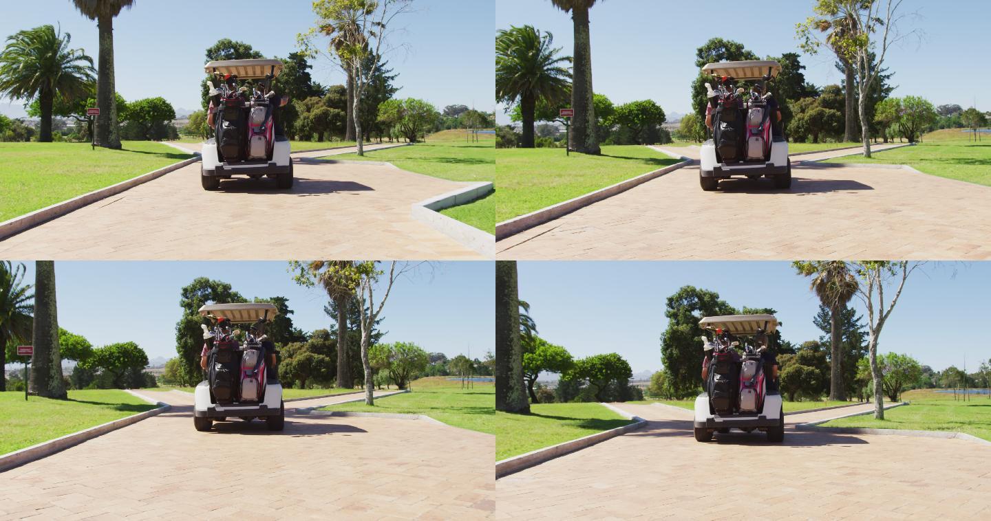 后视图的白人老年夫妇驾驶高尔夫球车与俱乐部在后面的高尔夫球场