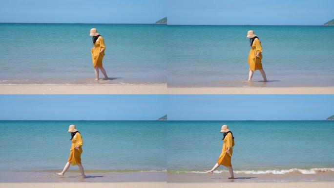 夏天的海南万宁，一个黄裙子美女在海边散步