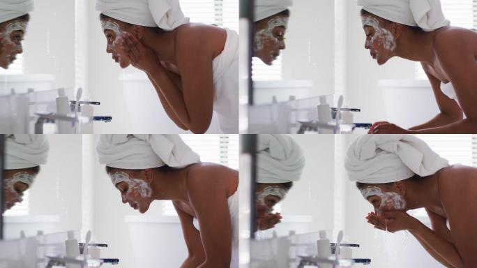 一位非裔美国妇女在家里浴室的水槽里洗她的面膜