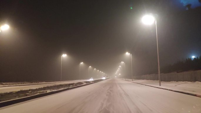 雪天在路灯白雪道路行驶