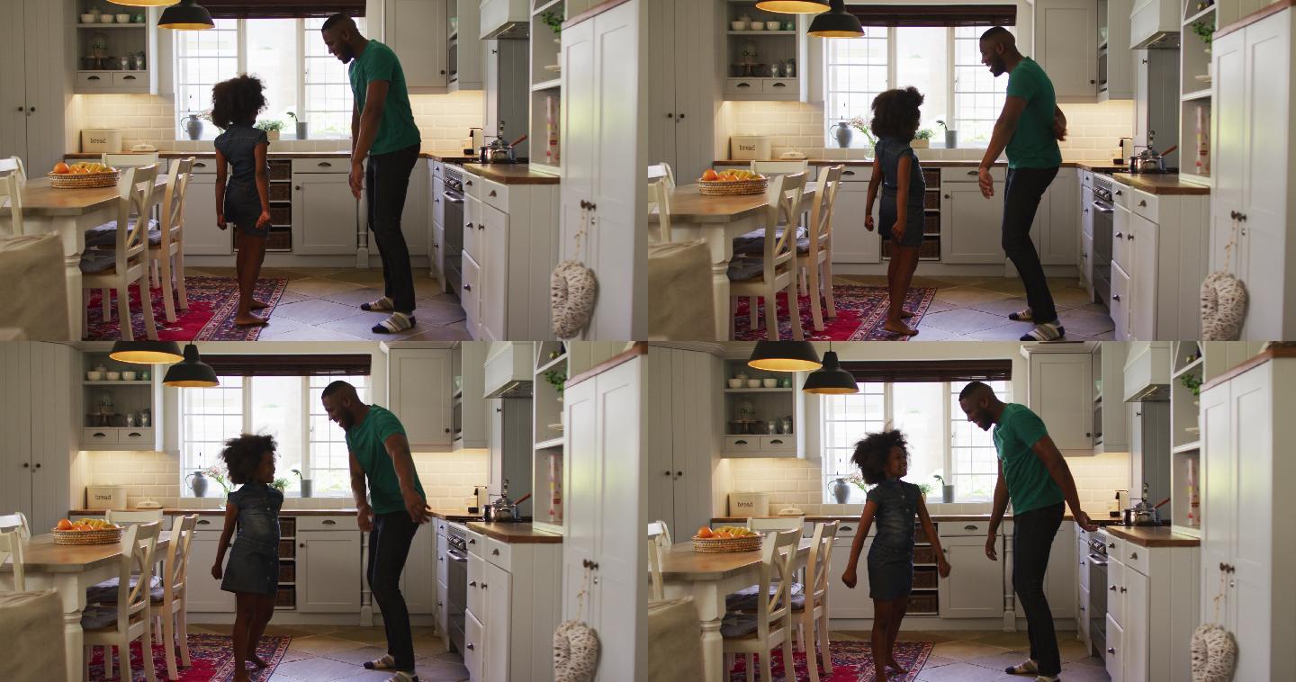 非裔美国人的女儿和她的父亲一起在厨房跳舞