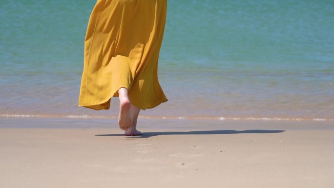 夏天的海南万宁，一个黄裙子美女在海边散步